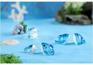 Close-up of five cute blue resin shark figurines for miniature ocean landscape decor