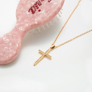 Close-up of 18K gold-plated cross pendant necklace with zircon inlay on white background