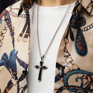 Détail d'un pendentif croix triple couche en argent porté avec une chaîne faite à la main