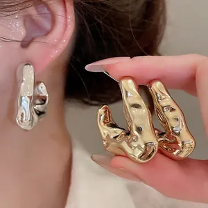 Lava texture C-shaped hoop earrings in gold and silver finish with liquid metal design