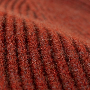 Deep brick red knit beanie with thick ribbed texture for a cozy winter outdoor style