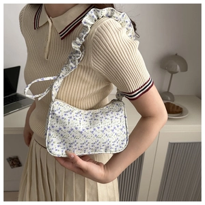 Close-up of floral fabric handbag with purple flower pattern and pleated shoulder strap