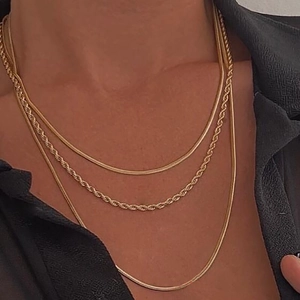 Detail of layered 18K gold plated titanium necklace with snake and twisted chains