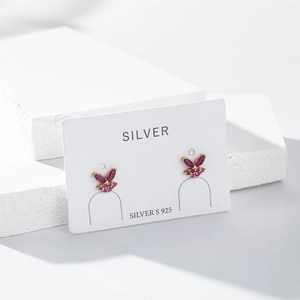 Detail view of S925 sterling silver butterfly stud earrings with pink cubic zirconia