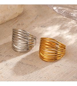 Detail of multi-layered 18K gold and silver plated stackable rings on stone surface