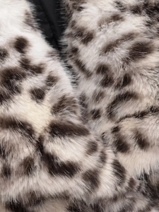 Detailaufnahme von Leopardenmuster-Kunstfell mit weichen cremefarbenen und schwarzen Fasern
