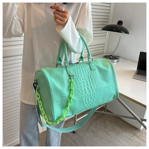 Large capacity light green crocodile embossed travel bag featuring a neon chain accent