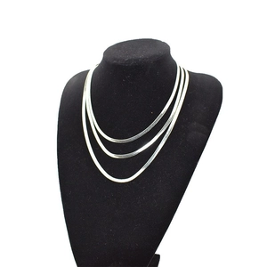 Elegant triple-layered silver snake chain necklace for women on black display stand