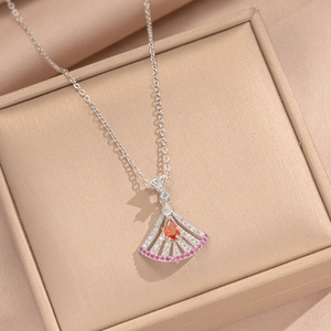 Elegant silver fan necklace with orange drop stone and colorful crystals on beige box