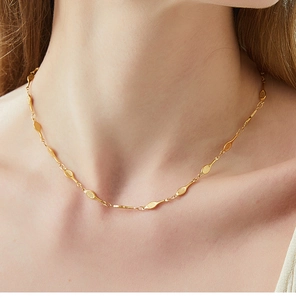 Close-up of golden tennis racket necklace on neck showing creative mesh link detail