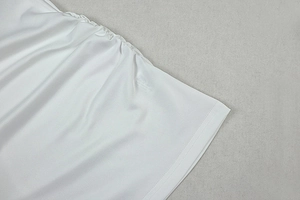 Detailansicht von weißem transparentem Stoff mit elastischen Falten und Doppelnaht-Saum