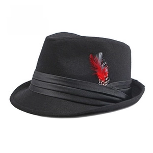 Detail of British style black felt fedora with striped band and feather accessory
