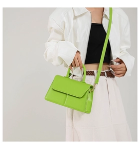 Lime green minimalist crossbody bag shown on model with shoulder strap and top handle
