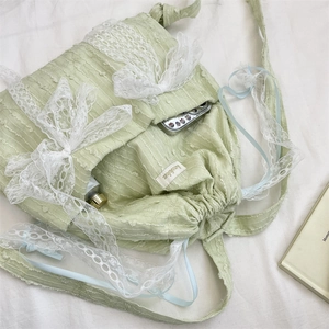 Close-up of light green lace bow backpack with drawstring closure and interior space