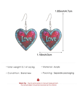 Detailed view of acrylic heart earrings with Love lettering and colorful mosaic patterns