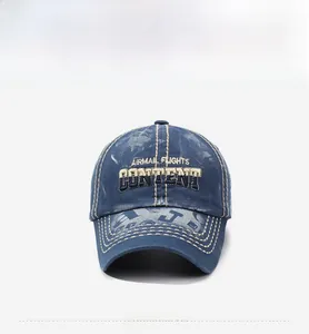 Detailed embroidery of AIRMAIL FLIGHTS lettering on a washed navy denim baseball cap