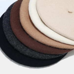 Detailopname van gestapelde wollen baret hoeden in zwart, grijs, bruin, camel en beige