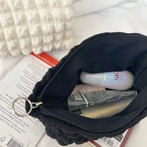 Black bubble textured makeup bag with silver ring zipper in a lifestyle setting