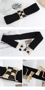 Detail of black elastic belt featuring a gold and black geometric metal clasp closure