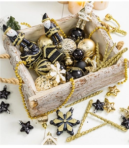 Close-up of elegant black and gold Christmas ball ornaments and stars in a wooden box