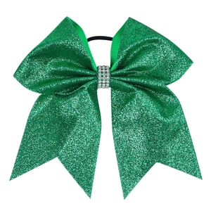 Detail of green glitter cheer bow with three rows of white rhinestones and black hair tie