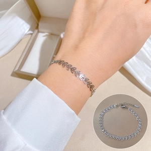 Minimalist silver four-leaf clover chain bracelet in titanium steel shown on female wrist