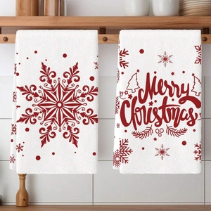 Detail of white cotton Christmas kitchen towels with red snowflake and Merry Christmas text