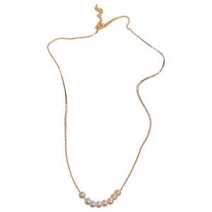 Minimalist geometric gold chain necklace with white pearls on a clean white background