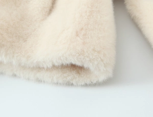Macro view of plush faux fur fabric in cream white showing soft texture and density