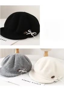Detail view of stylish wool blend newsboy cap with polka dot bow and leather label decoration