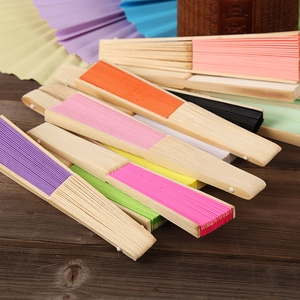 Assorted colorful 6-inch DIY paper folding fans with bamboo ribs on wood background