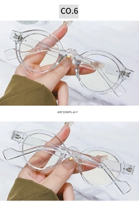 Detail view of transparent round glasses frame at a 45-degree angle with metal hinges