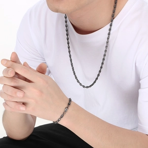 Detail of dark gray stainless steel anchor chain necklace and bracelet set on model