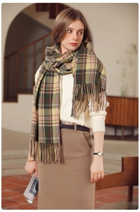 Detail of green and yellow plaid scarf with long fringes and soft wool-like texture