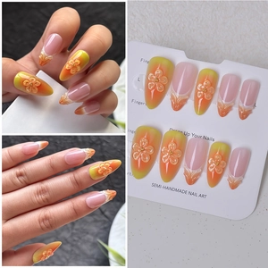 Detail of yellow-orange gradient almond press-on nails with 3D floral art and French tips