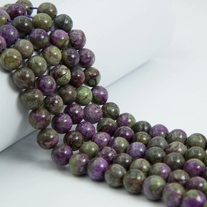 Macro shot of polished purple and green stichtite stone beads with marbled texture