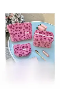 Three-piece plush heart pattern toiletry bags shown in a festive holiday gift setting
