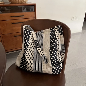 Borsa tote in tela a pois su una sedia di legno con etichetta in tessuto simple wish