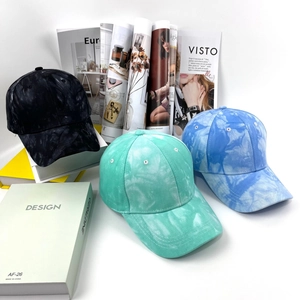 Dettaglio dei cappellini da baseball tie-dye in nero, verde menta e blu cielo