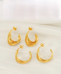 Vue détaillée de boucles d'oreilles créoles torsadées en acier plaqué or 18 carats