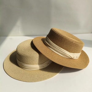 Draufsicht auf zwei geflochtene Strohhüte in Beige und Camel mit feiner Texturdetails