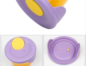 Close-up of purple silicone lid with yellow smiley button for glass baby food container
