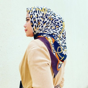Detail of satin square scarf with elegant leopard print and golden chain patterns