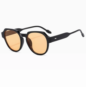 Detail of oval sunglasses with thick black frames and translucent orange lenses