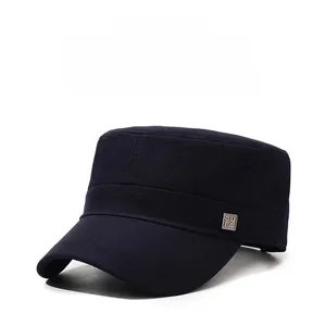 Detail of navy blue flat top military cap with square metal accent on a plain background