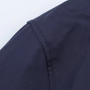Macro shot of durable shoulder stitching on this navy blue poplin shirt for women