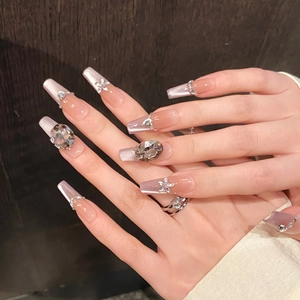 Detailed view of long coffin nails with purple gradient, silver glitter, and floral rhinestones