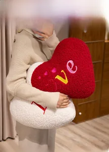 Detail view of plush heart-shaped cushions with LOVE embroidery in soft teddy fleece