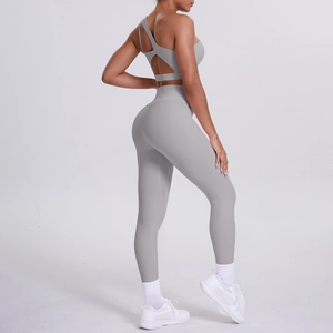 Detail of light gray one-shoulder yoga bra and high waist leggings on a model