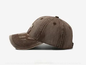 Macro detail of vintage washed brown cotton baseball cap with embroidered H logo